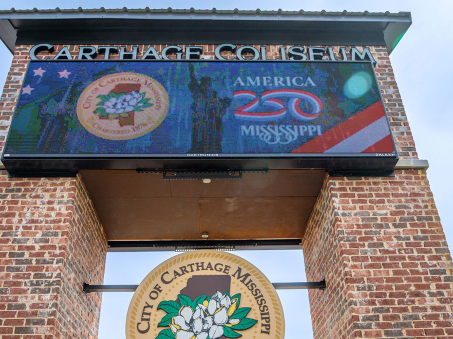 A brick arch has signs for the Carthage Coliseum.