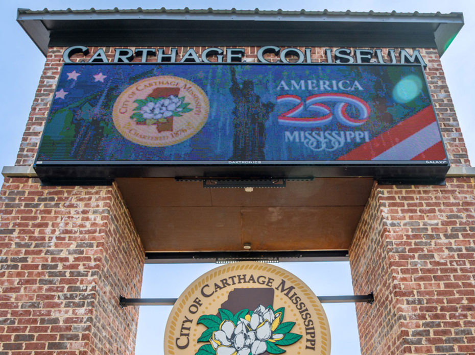 A brick arch has signs for the Carthage Coliseum.