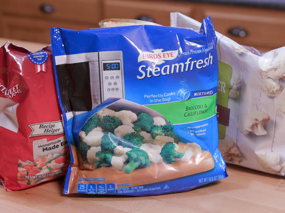 Three bags of frozen vegetables sit on a counter.