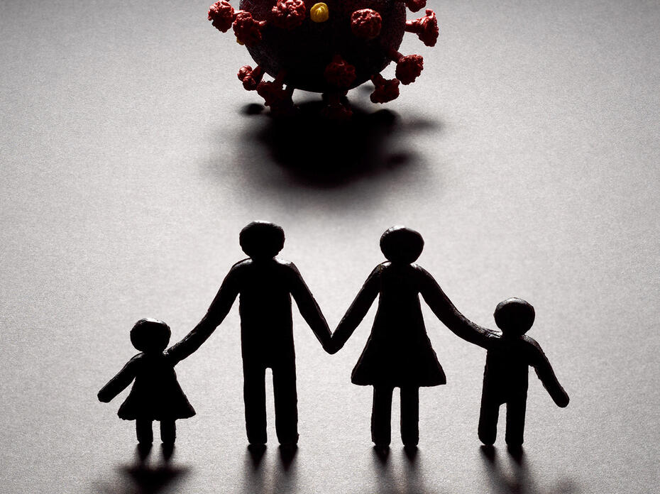 Silhouette of a paper cut-out style family of four facing a three-dimensional model of the novel coronavirus. 