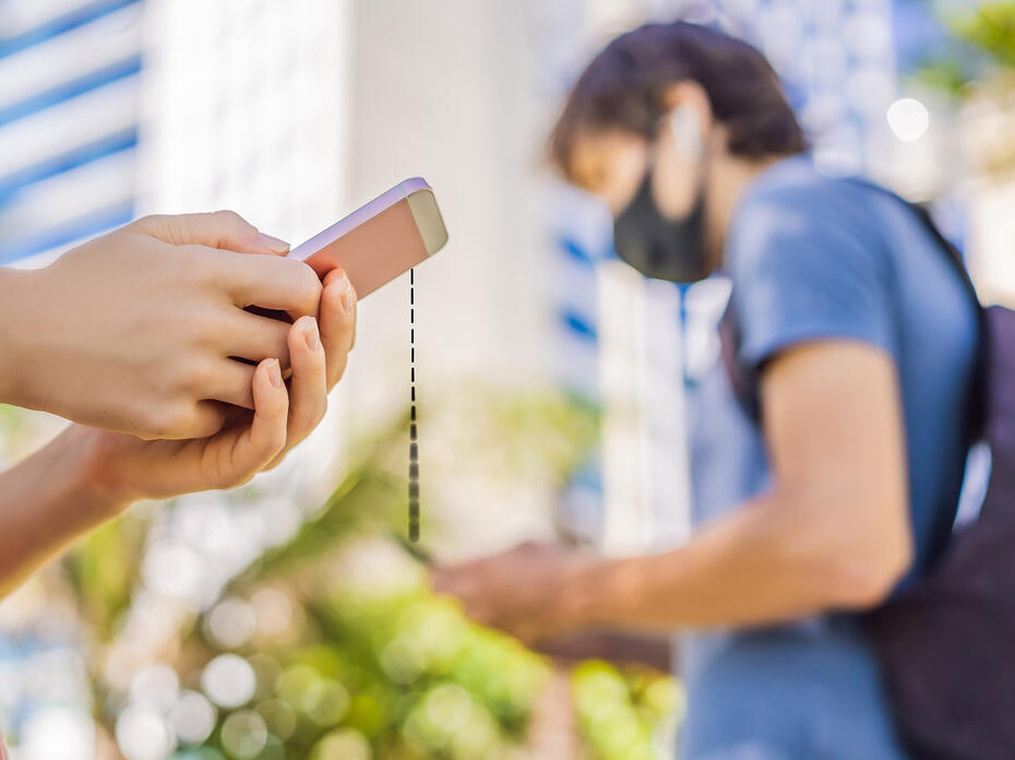 People wearing face masks holding cell phones