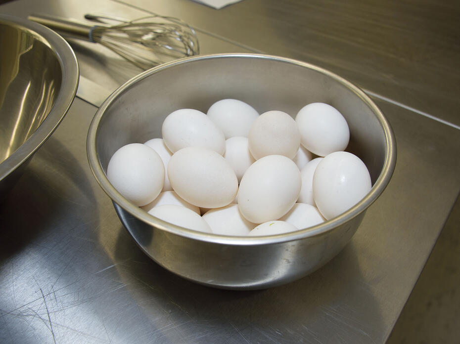 Several eggs sit in a bowl on a kitchen counter.
