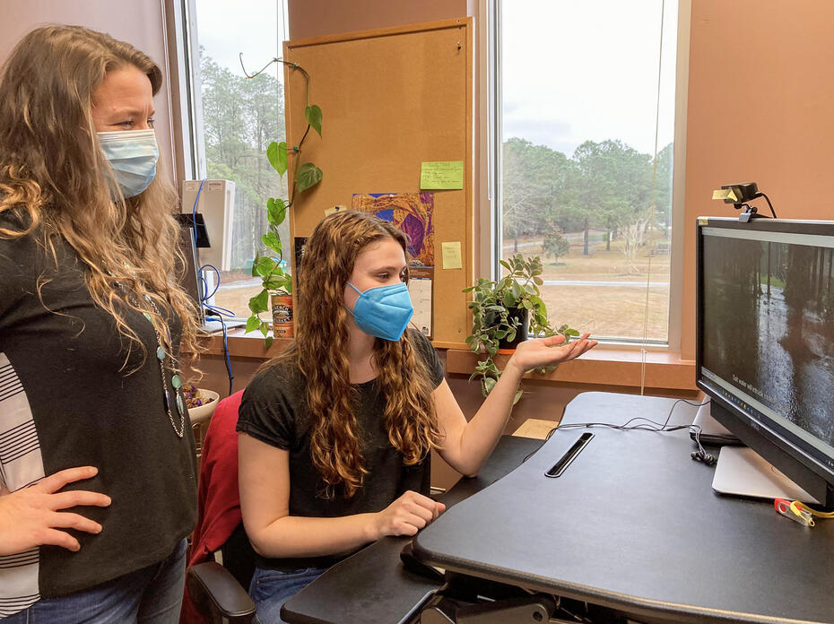 Two women work in an office setting.