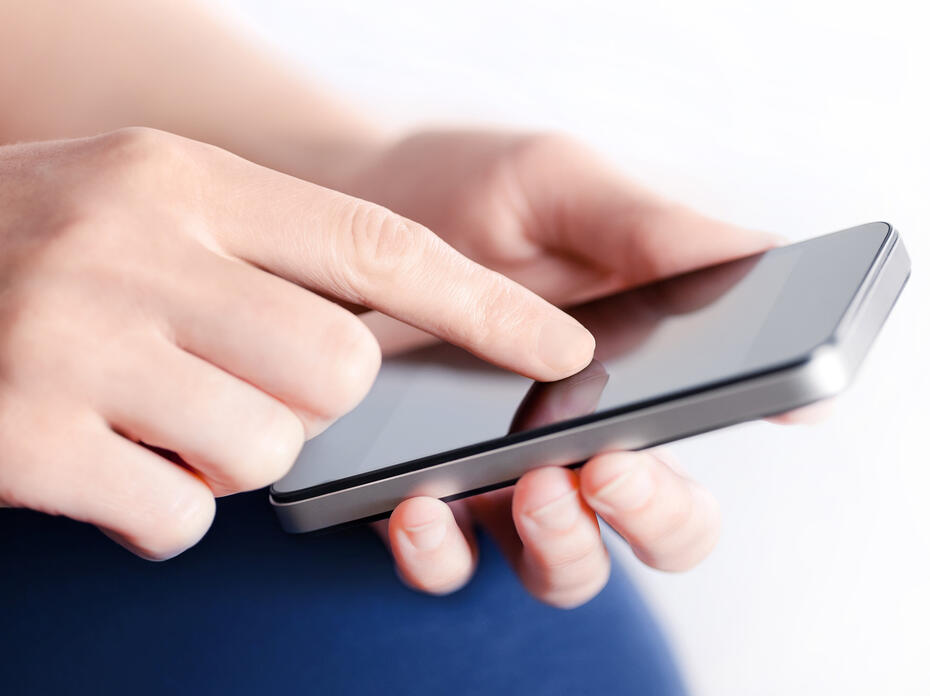 Hands holding a mobile phone.
