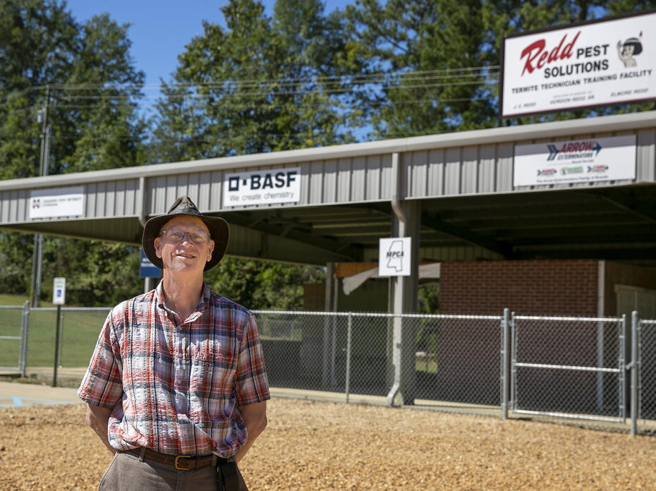 A man stands outside a structure.