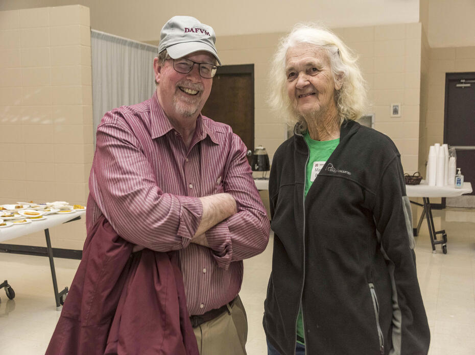 A man and a woman stand together in a meeting space.