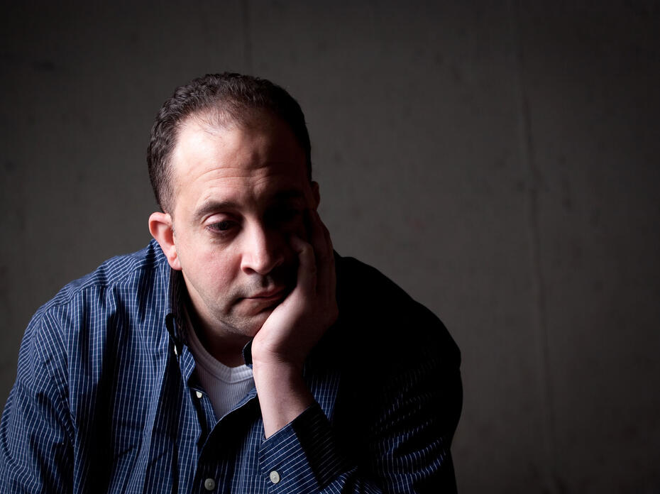 Stressed-out man with head in his hands.