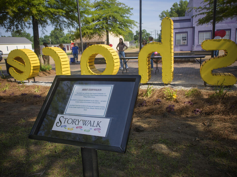 Yellow letters stand in the background behind a marker post.