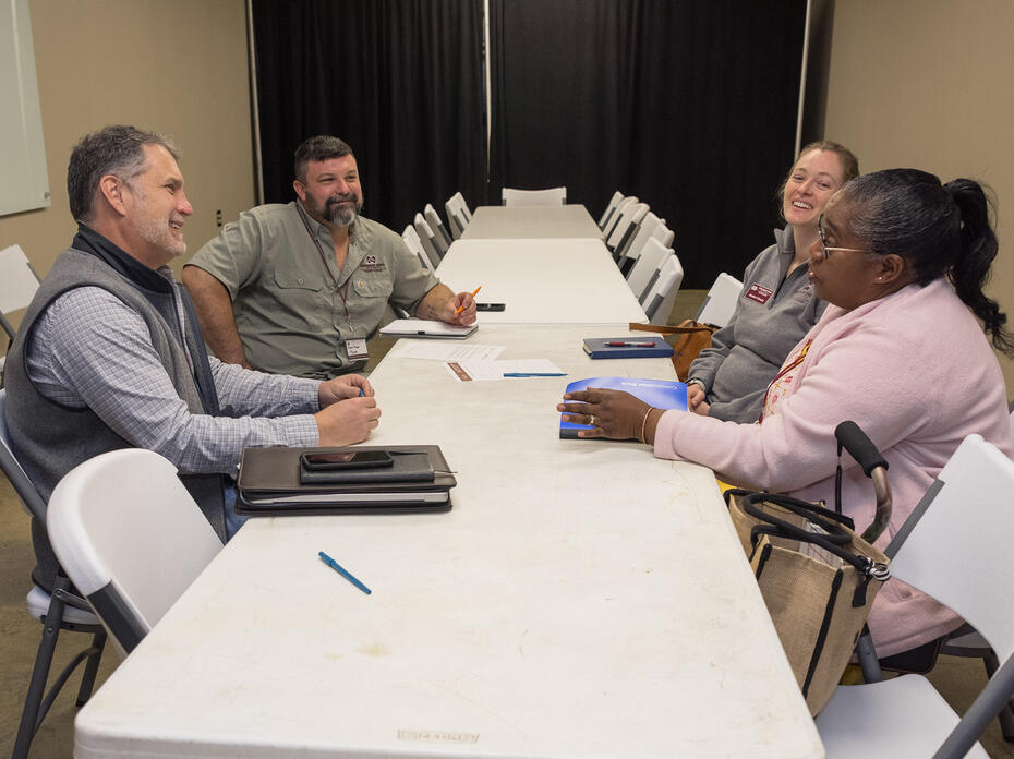 Four people at a table talking to each other.