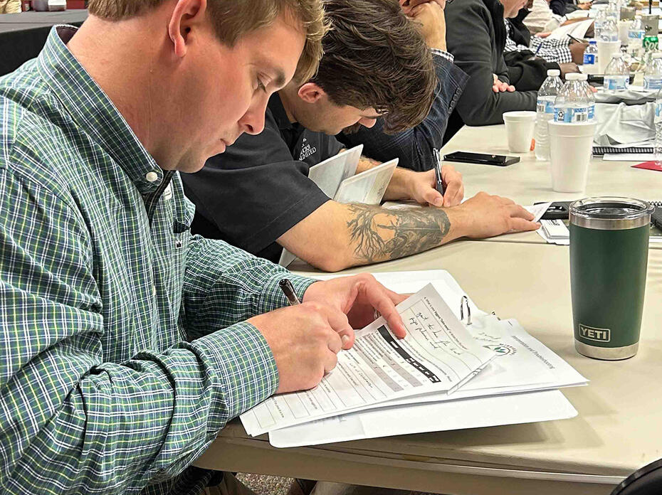 Adults do paperwork at tables.