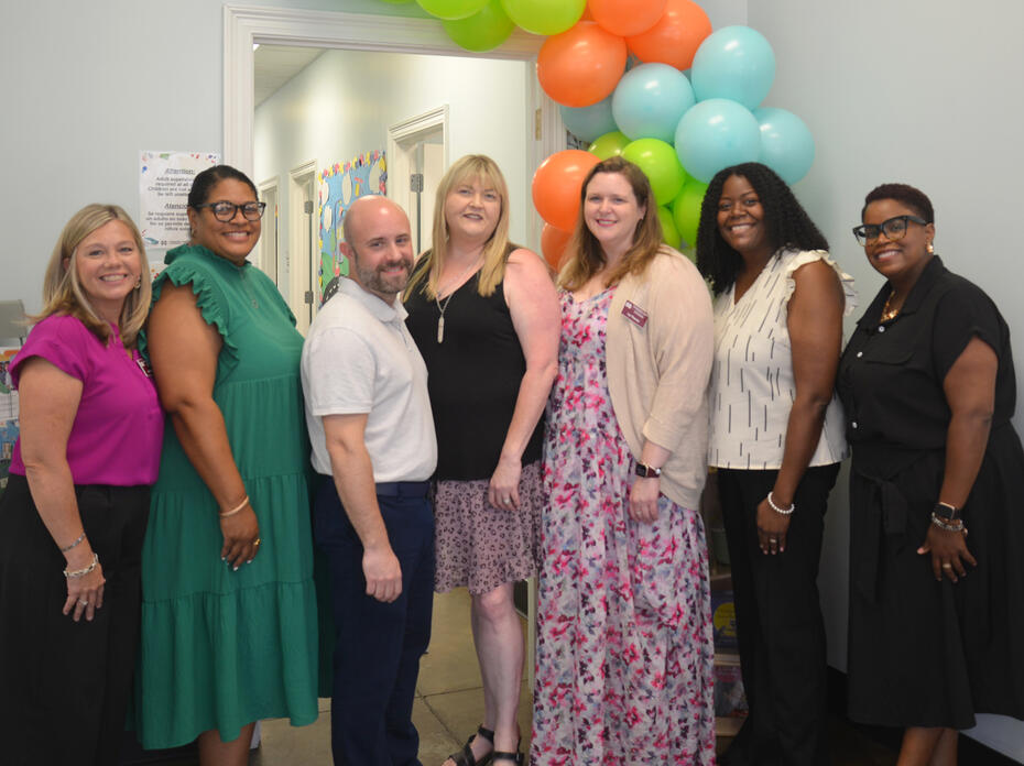 People pose for a photo during an open house event.
