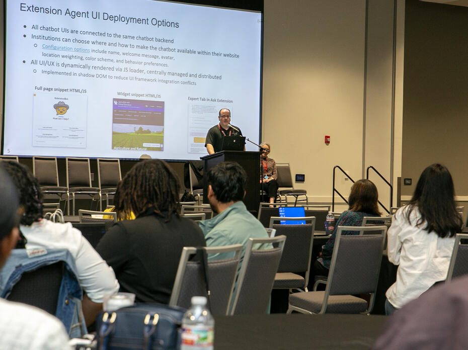 Two people are on stage during a presentation.
