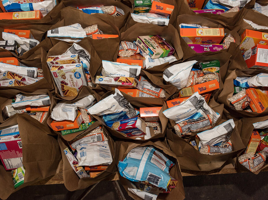 An assortment of food items inside paper grocery bags