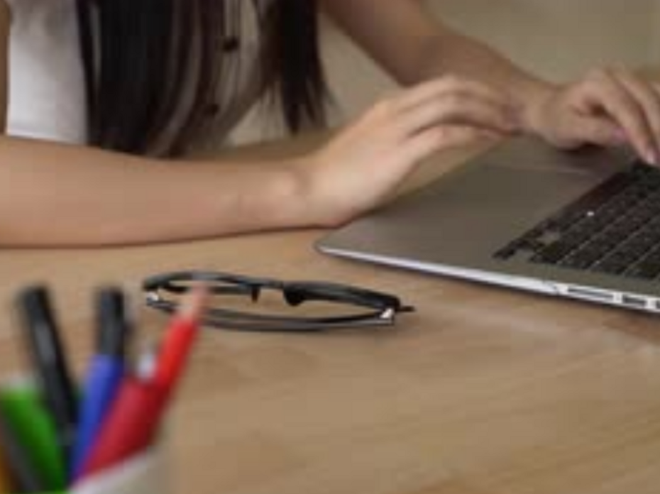 Hands typing on laptop keyboard