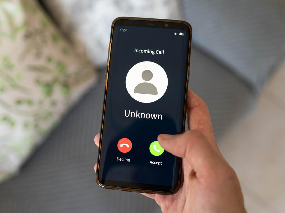 Concept of an imcoming call from an unknown number. Hand holding a cell phone.
