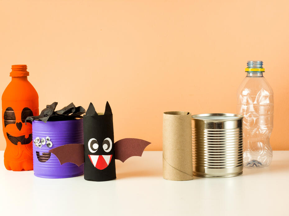 Homemade pumpkin, bat, monster Halloween decor with a toilet paper roll, tin can, and water bottle.