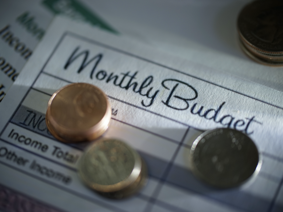 Coins stacked on a monthly budgeting form.