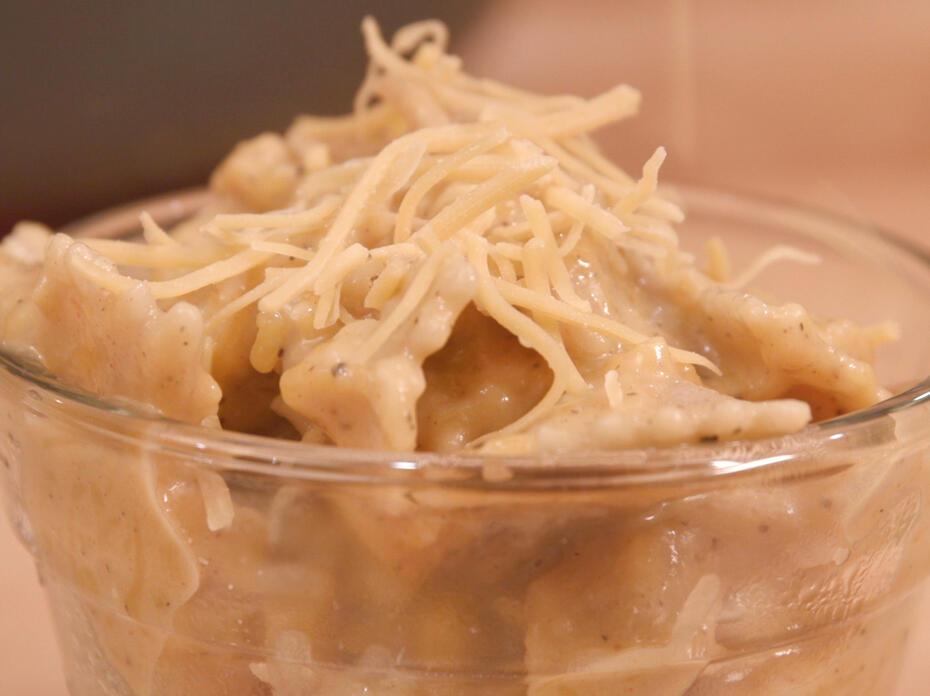 Butternut macaroni and cheese in a clear glass bowl.