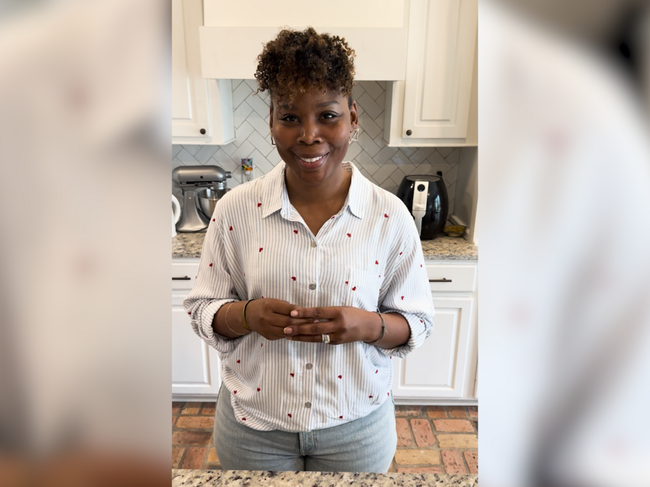 A woman stands in a kitchen.