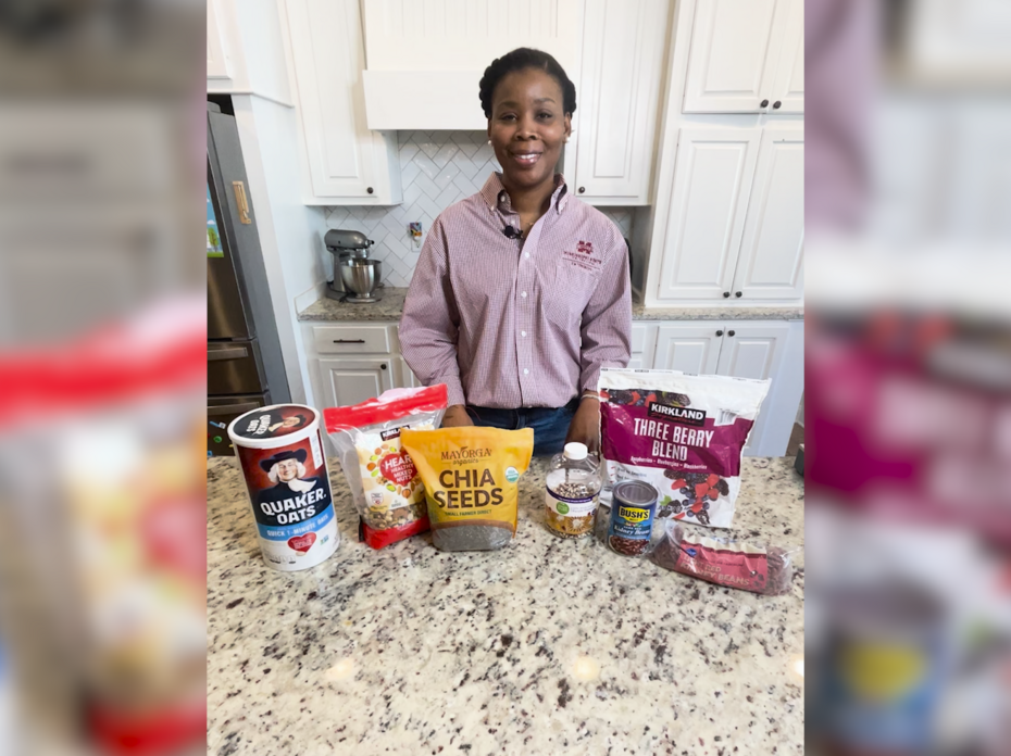 A woman stands in a kitchen with high-fiber foods on the counter.
