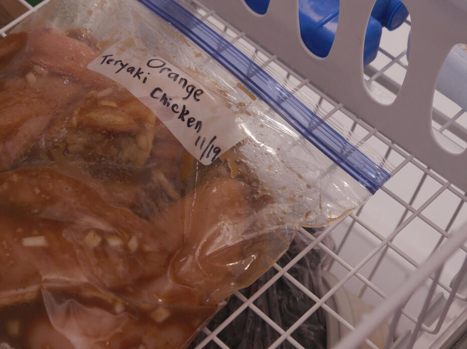 A labeled zip-top bag of Orange Teriyaki Chicken in the freezer.