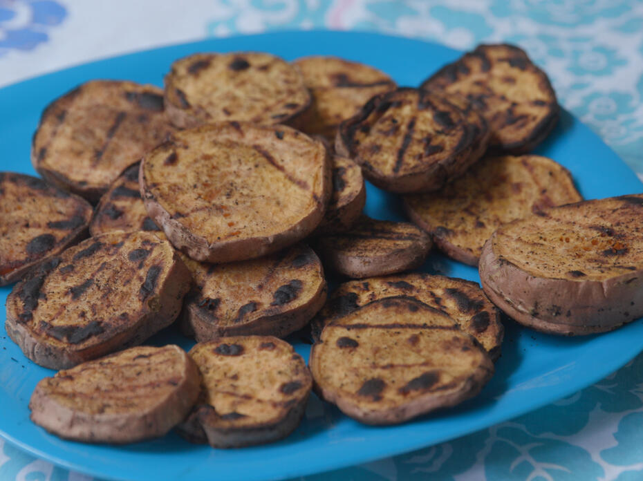 Grilled sweet potato slices on a bright turquoise blue plate