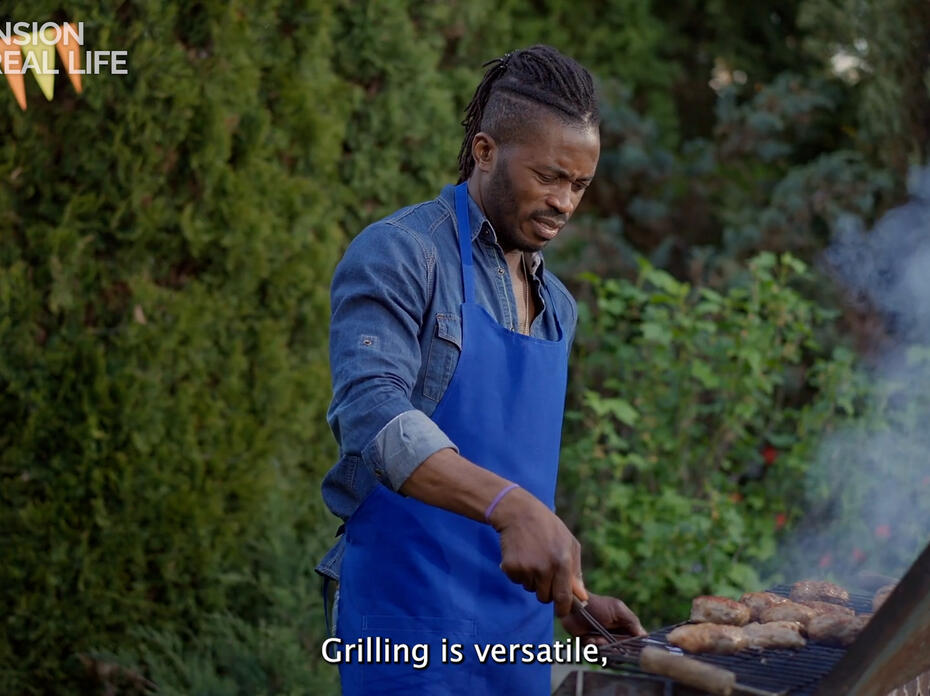 A man cooks food on a grill.