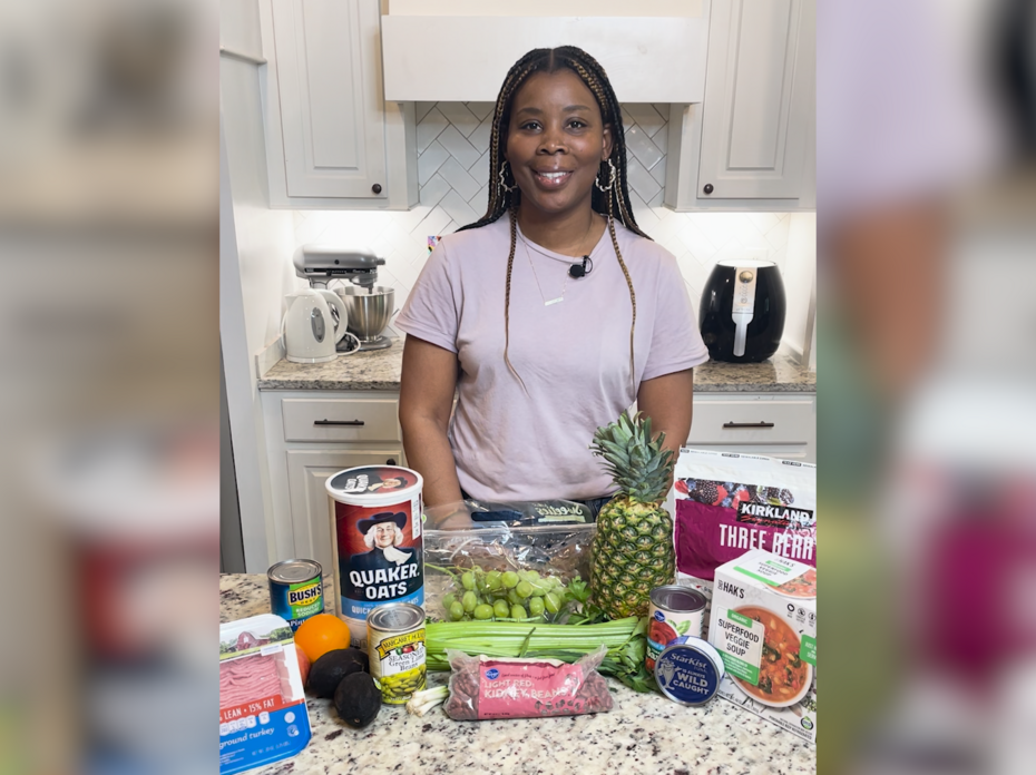 A woman stands in front of a kitchen counter filled with food products.