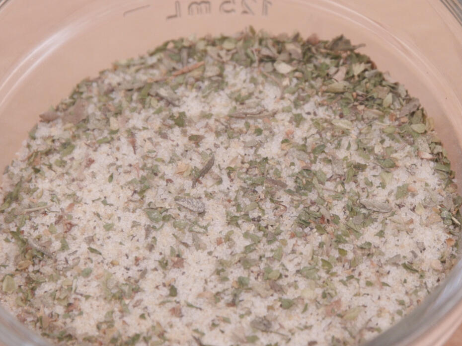 A mixture of spices and salt in a clear glass bowl