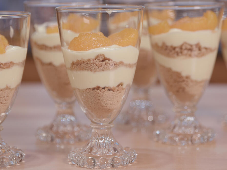 Clear glass parfait cups with lemon pudding layered with graham cracker crumbs topped with manadarin orange slices
