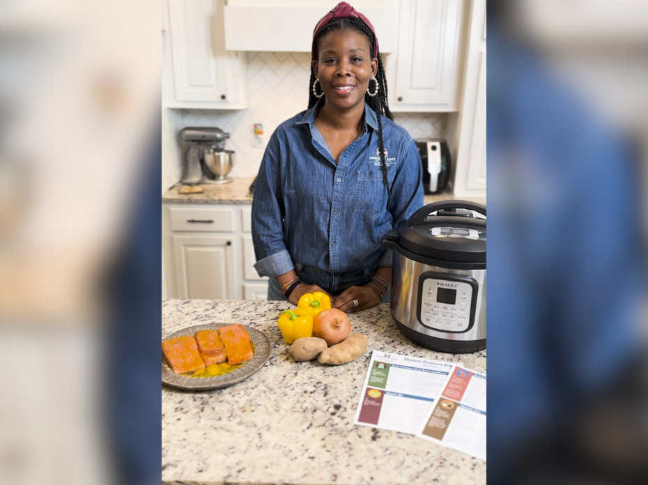 A woman stands in a kitchen with an electric pressure cooker.