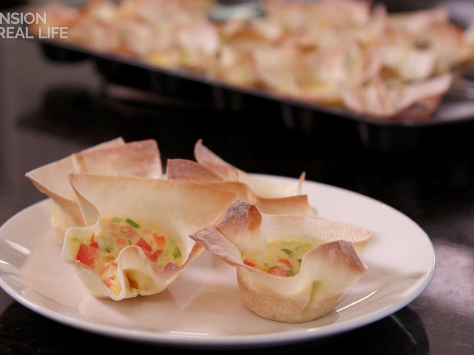Four mini wonton quiche sit on a plate.