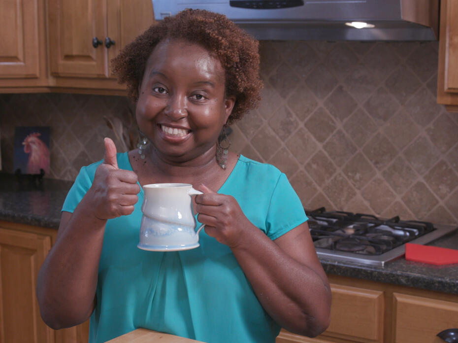 Food Factor host Natasha Haynes holds a mug of cocoa while standing in a kitchen