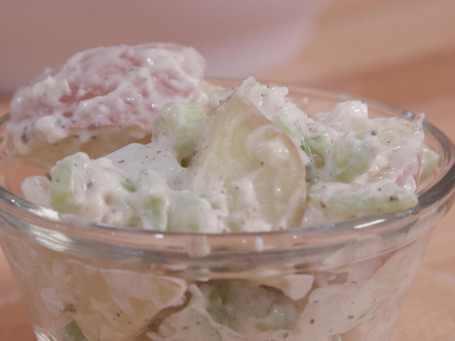 Potato salad in a small clear glass bowl
