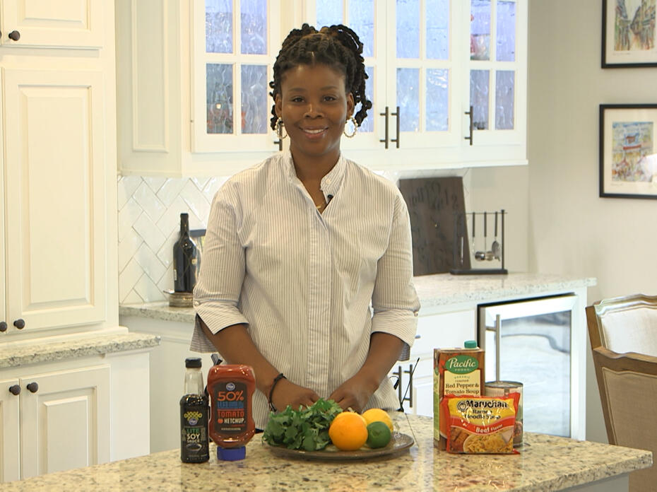 A woman stands behind a kitchen counter.