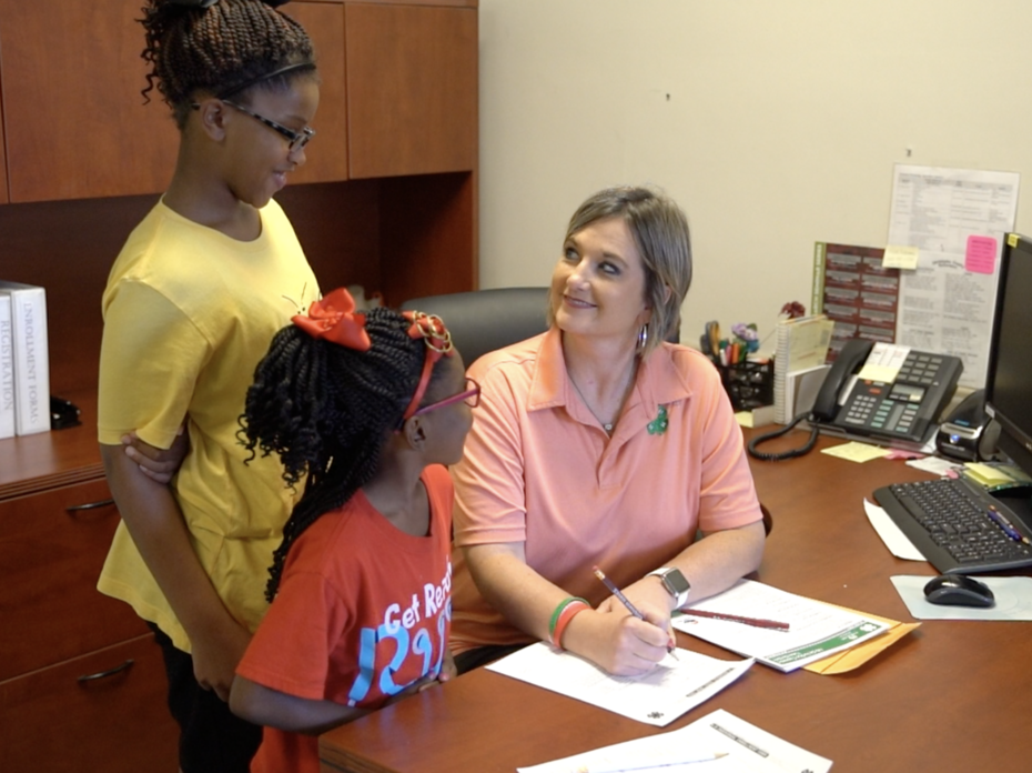 Woman filling out paper work with two children. 