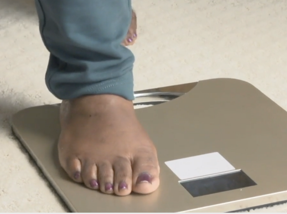 A close up picture of a person's foot stepping on a scale. 