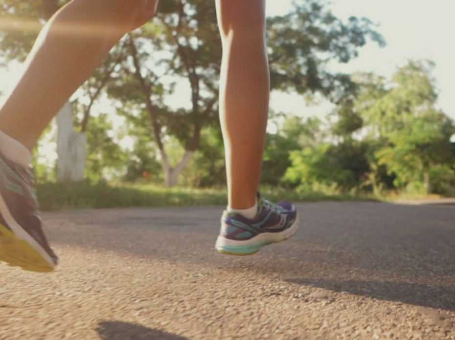 A person running with purple tennis shoes on. 