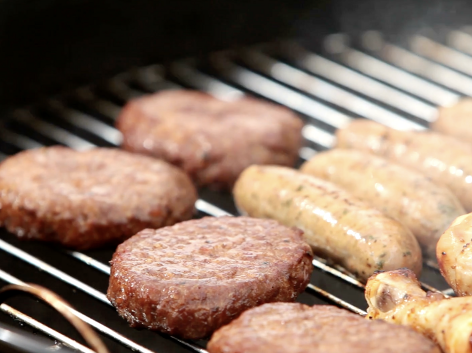 Hamburgers, chicken and hotdogs on a grill. 