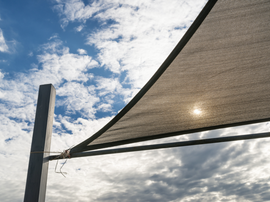 A shade sail with cloudy blue sky.