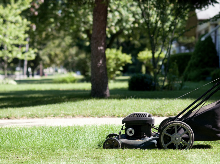 A black lawn mower mowing a yard.