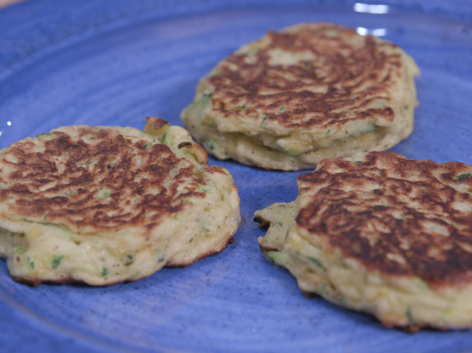 three zucchini fritters on a blue plate
