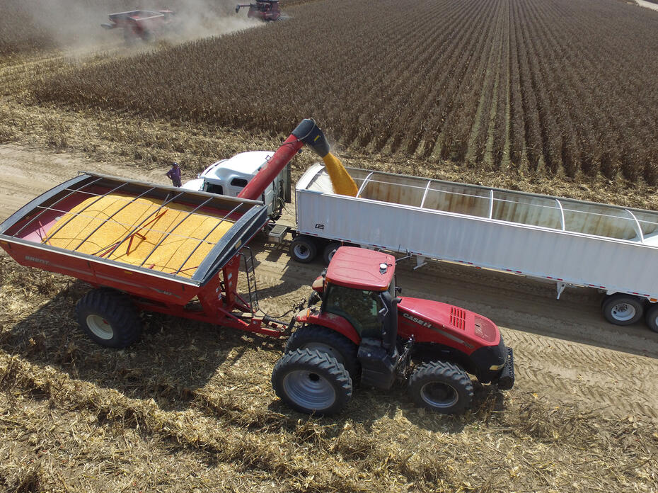 Aerial view of a tractor and a load of grain being transferred.