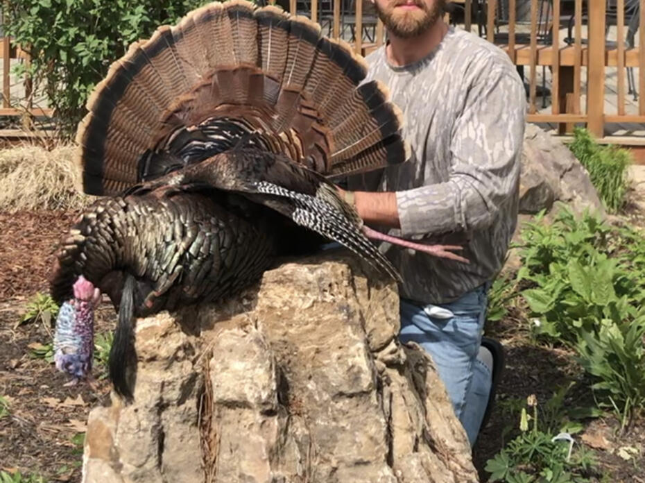 A hunter shows off a turkey he harvested.