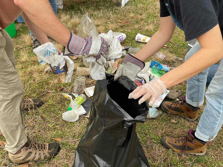 People put trash into a trash bag.