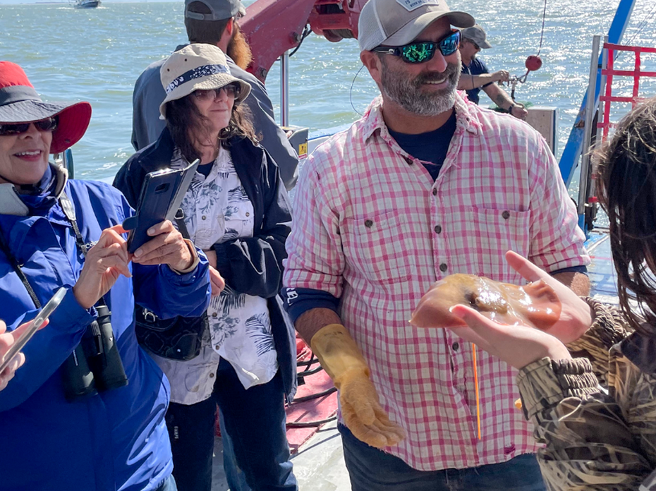 Man showing fish to group