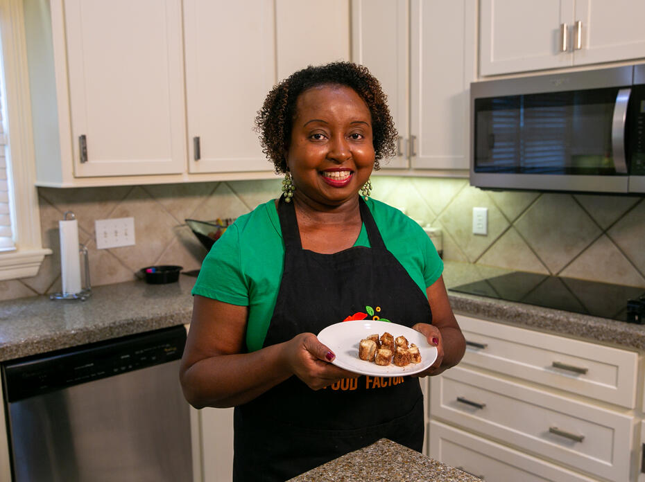 A woman in a kitchen holds a plate of Cinnamon Swirls.