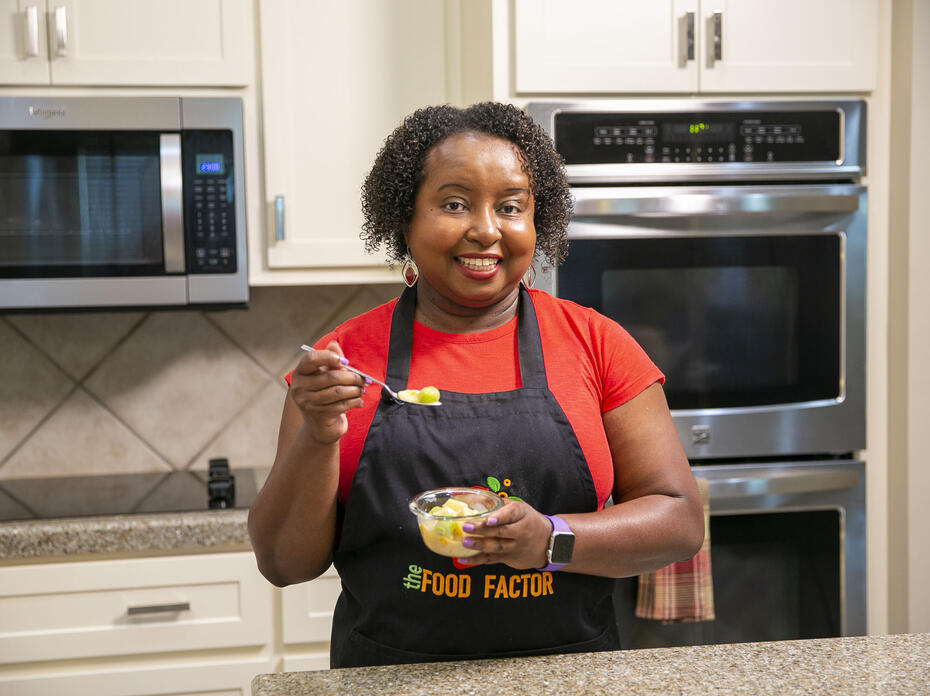 A woman stands in a kitchen with a bowl of Fruit Paradise