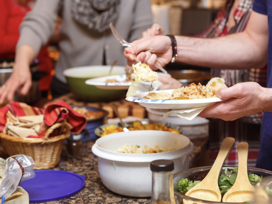 People serve their plates at a buffet-style dinner.