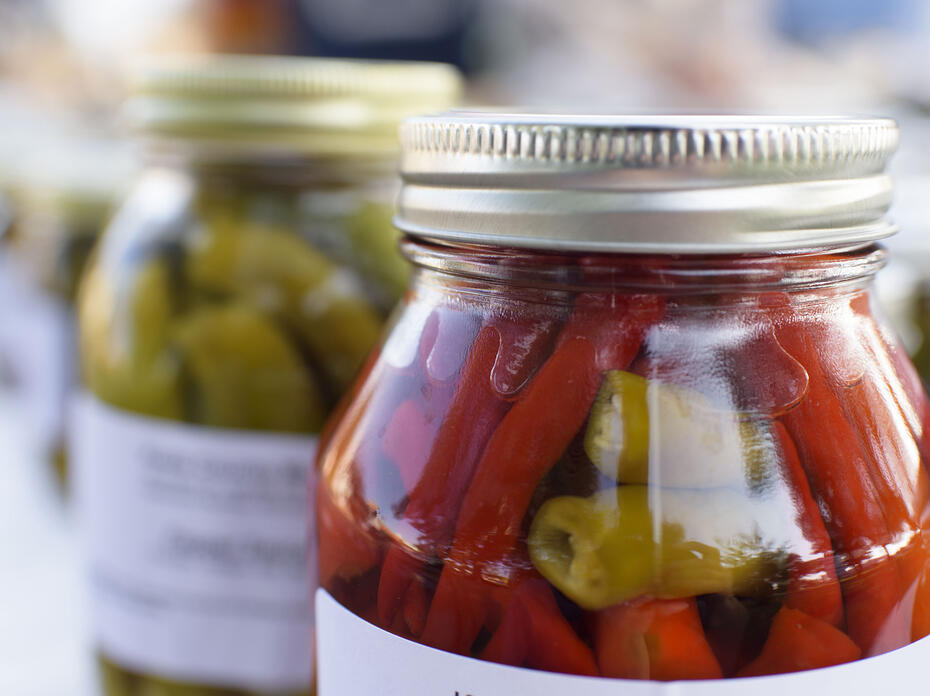 A glass jar with a metal lid is full of vegetables.